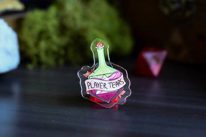 Pin with 'Player Tears' design on a dark surface